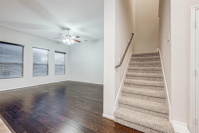 staircase with hardwood / wood-style floors and ceiling fan