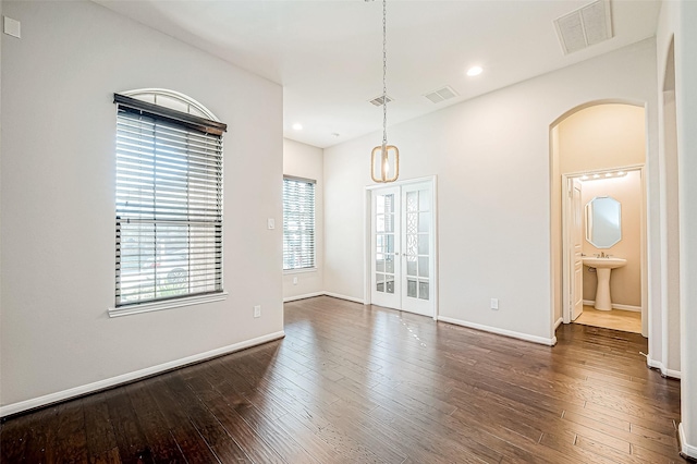 unfurnished room featuring french doors and dark wood-type flooring