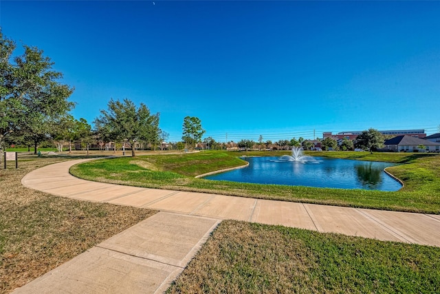 view of swimming pool with a lawn and a water view