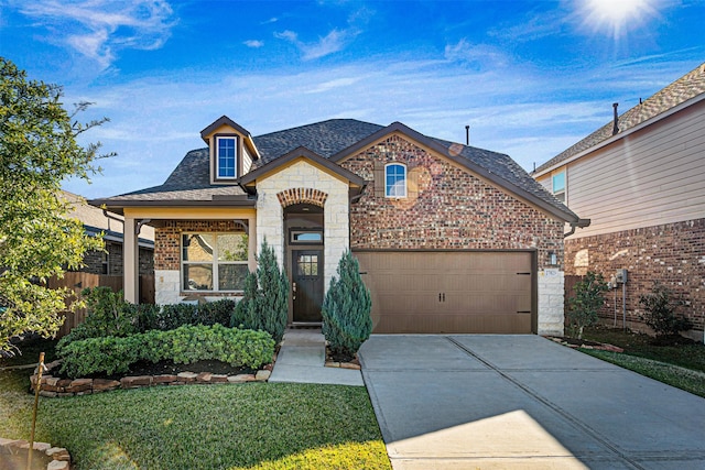 french country inspired facade with a front yard and a garage