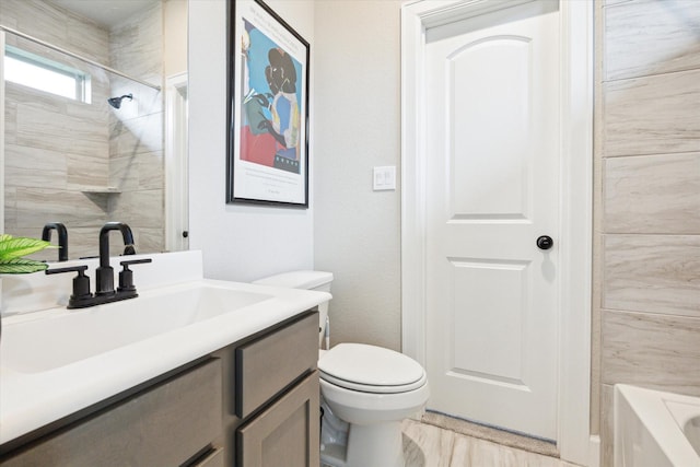 full bathroom featuring tiled shower / bath combo, vanity, and toilet