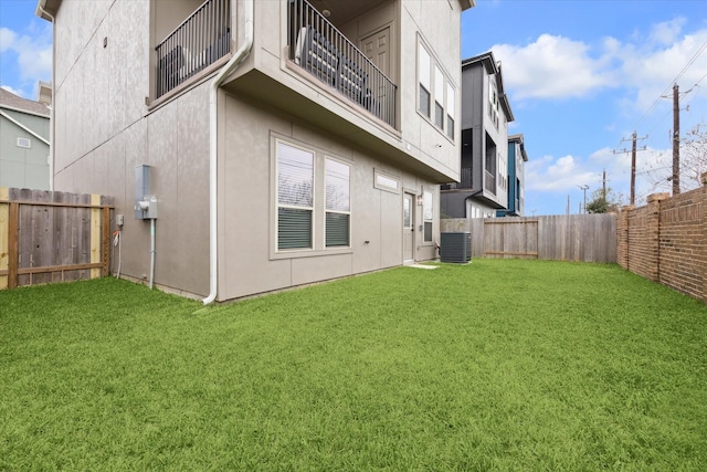 rear view of house featuring a yard and central air condition unit