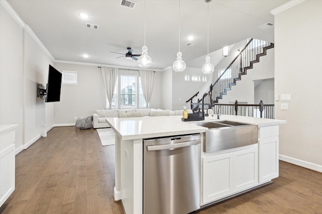 kitchen with dishwasher, sink, white cabinets, hanging light fixtures, and a center island with sink