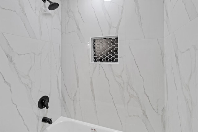 room details with tiled shower / bath combo