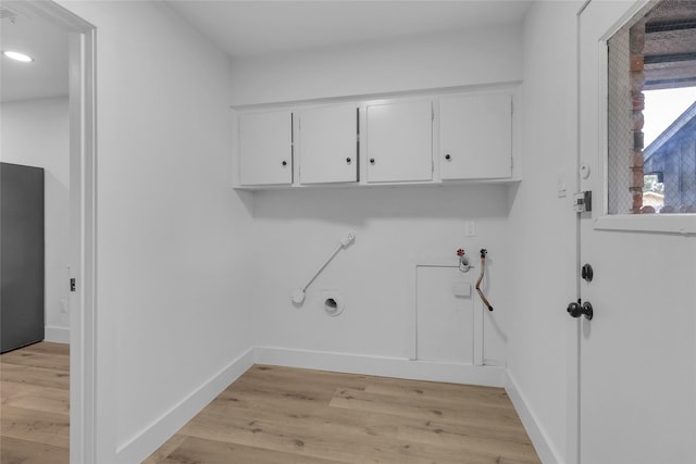 washroom featuring cabinets, light hardwood / wood-style floors, and gas dryer hookup