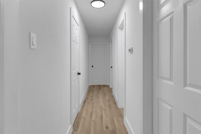 hallway with light hardwood / wood-style floors