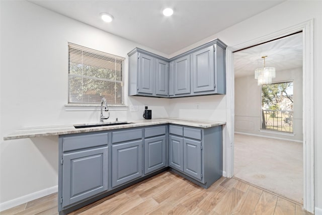 kitchen with plenty of natural light, sink, hanging light fixtures, and an inviting chandelier