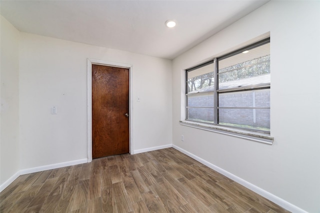 empty room featuring plenty of natural light and hardwood / wood-style floors