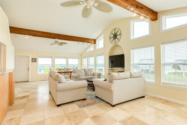 living area with beam ceiling, a healthy amount of sunlight, and baseboards