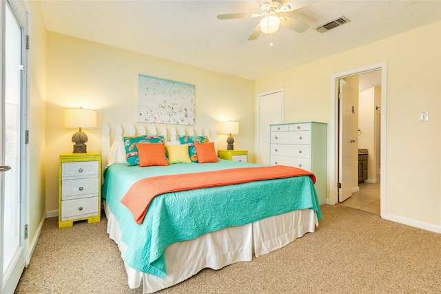 carpeted bedroom featuring a ceiling fan, connected bathroom, visible vents, and baseboards