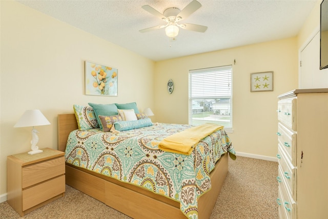 bedroom featuring ceiling fan, baseboards, a textured ceiling, and light colored carpet