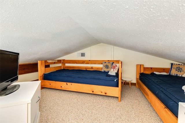 bedroom featuring visible vents, vaulted ceiling, and a textured ceiling