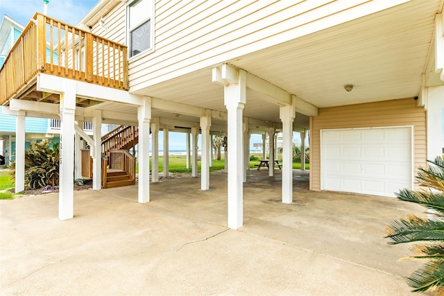 view of patio / terrace featuring a garage, a carport, stairs, and driveway