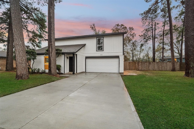 front of property with a garage and a lawn