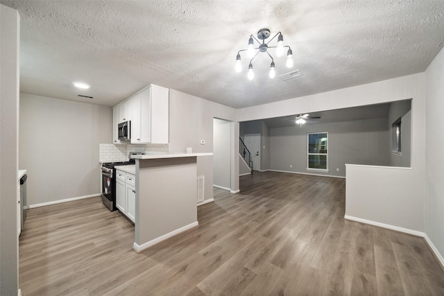 kitchen featuring appliances with stainless steel finishes, light hardwood / wood-style floors, ceiling fan, decorative backsplash, and white cabinets