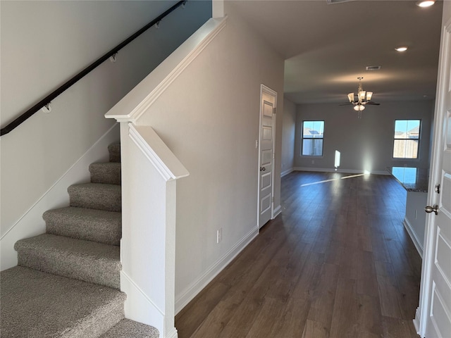 stairway featuring wood-type flooring and ceiling fan