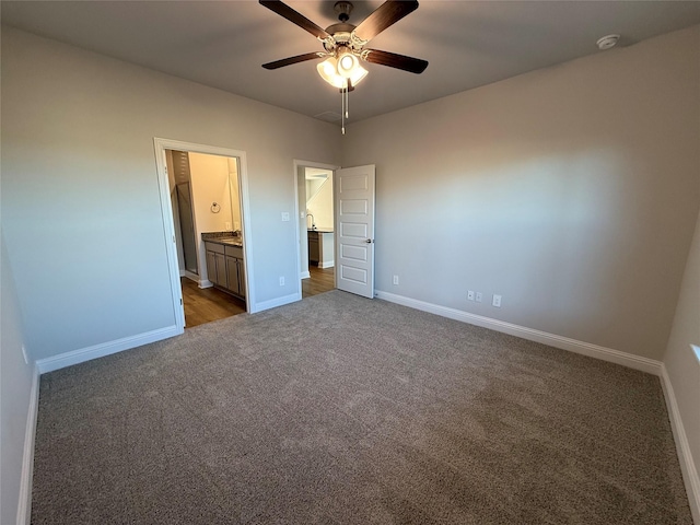 unfurnished bedroom with dark colored carpet, ceiling fan, and ensuite bathroom