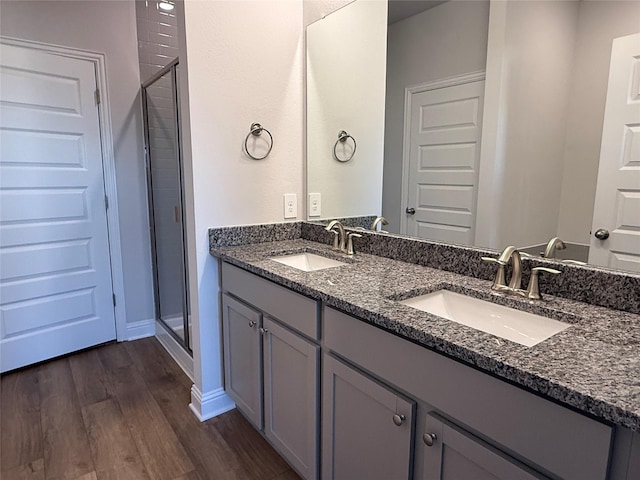 bathroom featuring hardwood / wood-style floors, vanity, and a shower with shower door