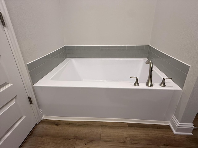 bathroom featuring hardwood / wood-style flooring and a tub