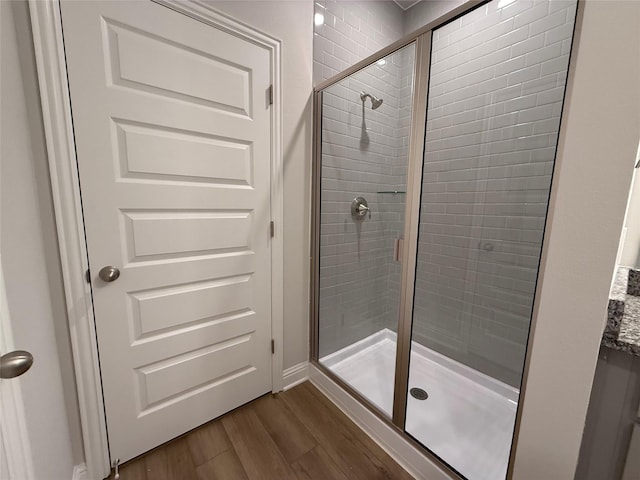 bathroom with hardwood / wood-style floors and walk in shower