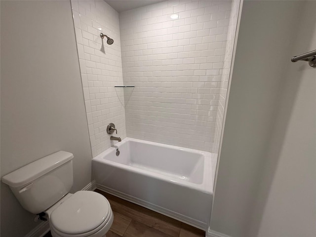 bathroom featuring hardwood / wood-style floors, toilet, and tiled shower / bath