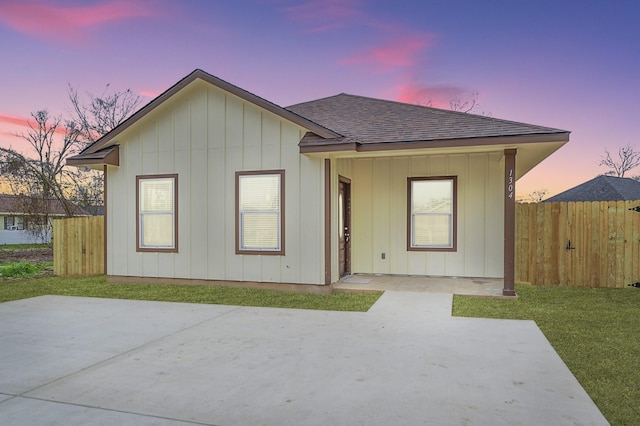 view of front of property with a patio and a lawn