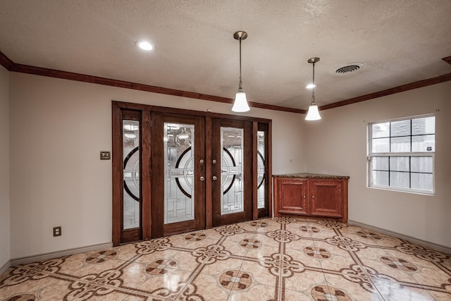 tiled entrance foyer featuring crown molding, french doors, and a textured ceiling