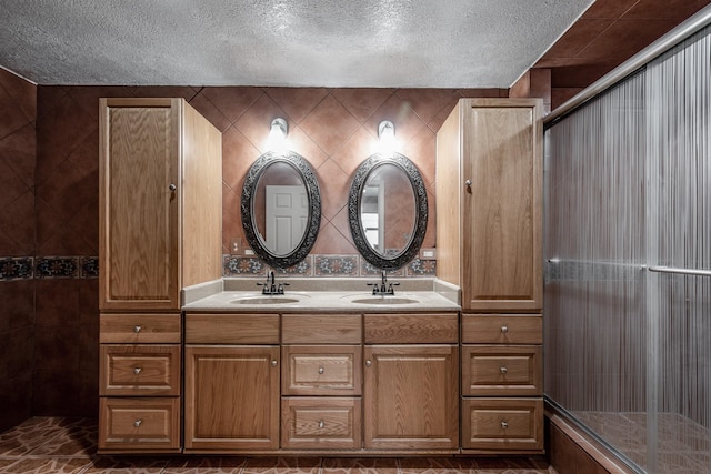 bathroom with vanity, a textured ceiling, and walk in shower