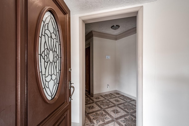 interior space featuring tile patterned floors, ornamental molding, and a textured ceiling