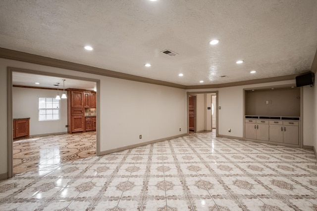 unfurnished living room with a textured ceiling and ornamental molding