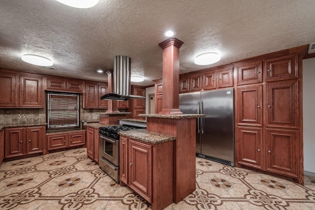 kitchen with a center island, ornate columns, island exhaust hood, and appliances with stainless steel finishes