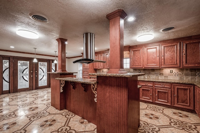 kitchen featuring french doors, a center island, crown molding, stone countertops, and island range hood