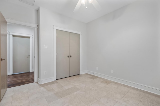 unfurnished bedroom with ceiling fan and a closet