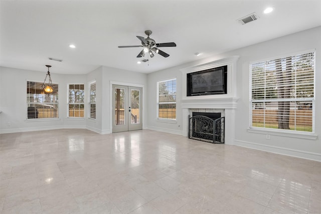 unfurnished living room with ceiling fan and french doors