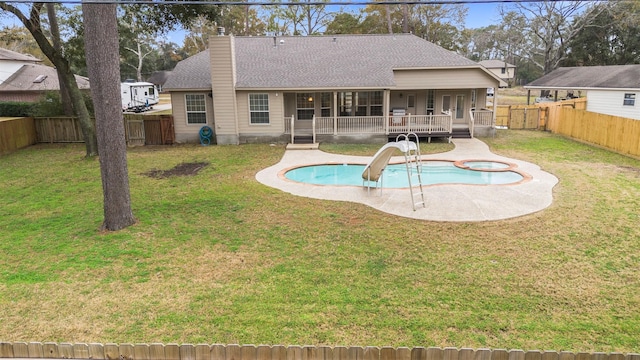 back of property with a patio area, a lawn, and a swimming pool side deck