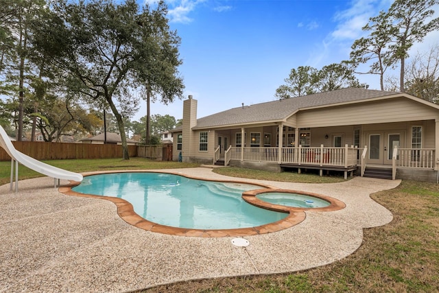 view of swimming pool featuring a patio, a deck, an in ground hot tub, a water slide, and french doors