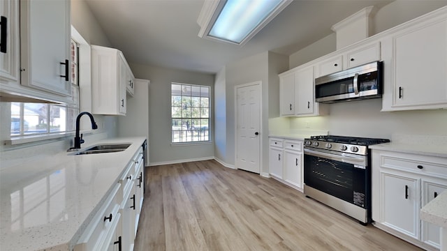 kitchen featuring white cabinetry, sink, and appliances with stainless steel finishes