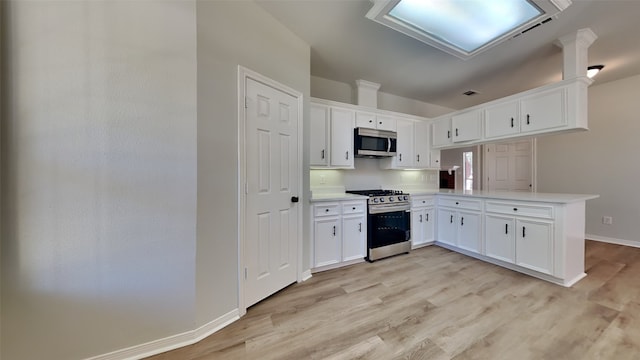 kitchen with kitchen peninsula, white cabinets, stainless steel appliances, and light hardwood / wood-style floors