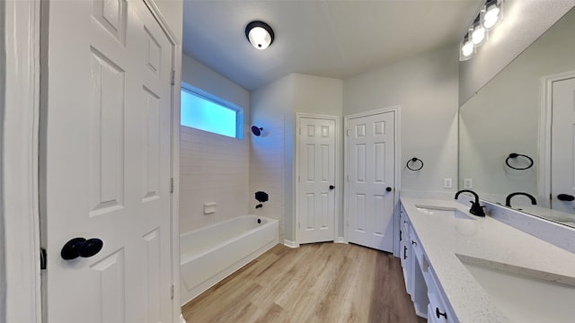 bathroom with bathing tub / shower combination, vanity, and hardwood / wood-style flooring