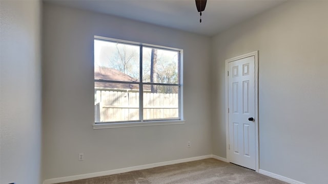 carpeted empty room featuring ceiling fan