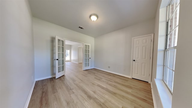 spare room with french doors and light hardwood / wood-style floors