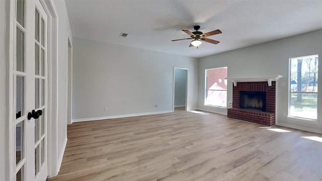 unfurnished living room featuring a fireplace, a textured ceiling, light wood-type flooring, and ceiling fan