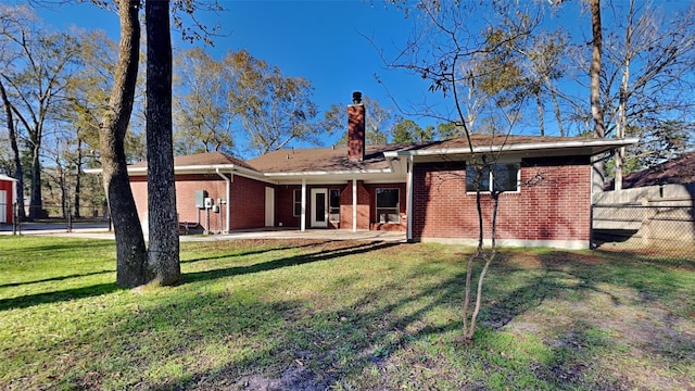 back of property featuring a lawn and a patio