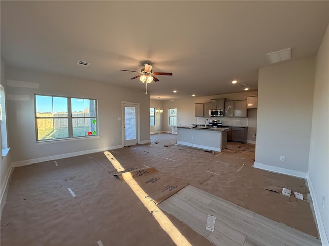 unfurnished living room with ceiling fan