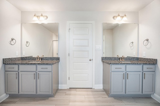 5307 W Bayou Maison Cir, Dickinson, TX 77539 - bathroom featuring wood finish floors, two vanities, and a shower