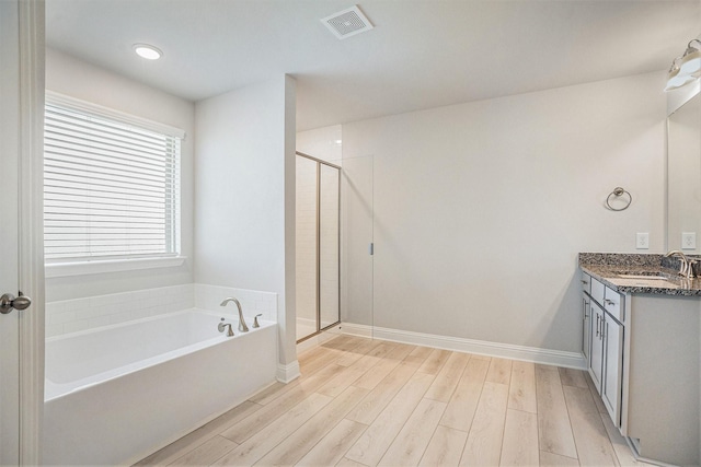 5307 W Bayou Maison Cir, Dickinson, TX 77539 - bathroom with vanity, a bath, wood finished floors, and a shower stall