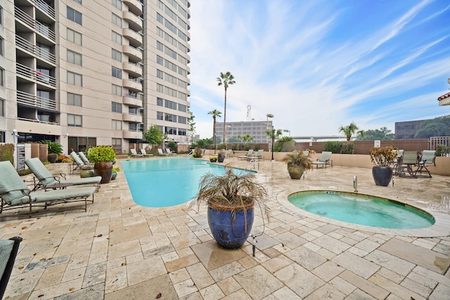 view of swimming pool featuring a patio area and a hot tub