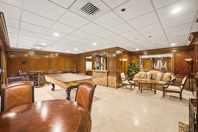 rec room with a paneled ceiling, crown molding, wooden walls, and pool table