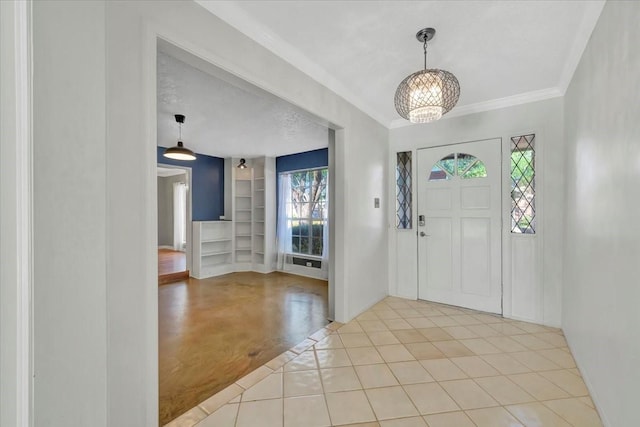 entrance foyer with light tile patterned floors, a chandelier, a textured ceiling, and ornamental molding