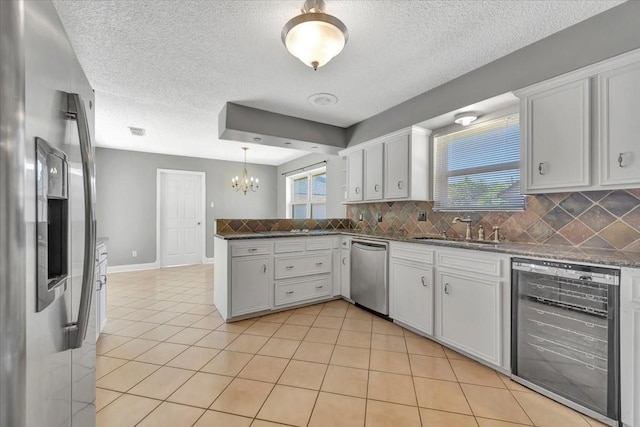 kitchen with tasteful backsplash, white cabinetry, sink, and stainless steel appliances